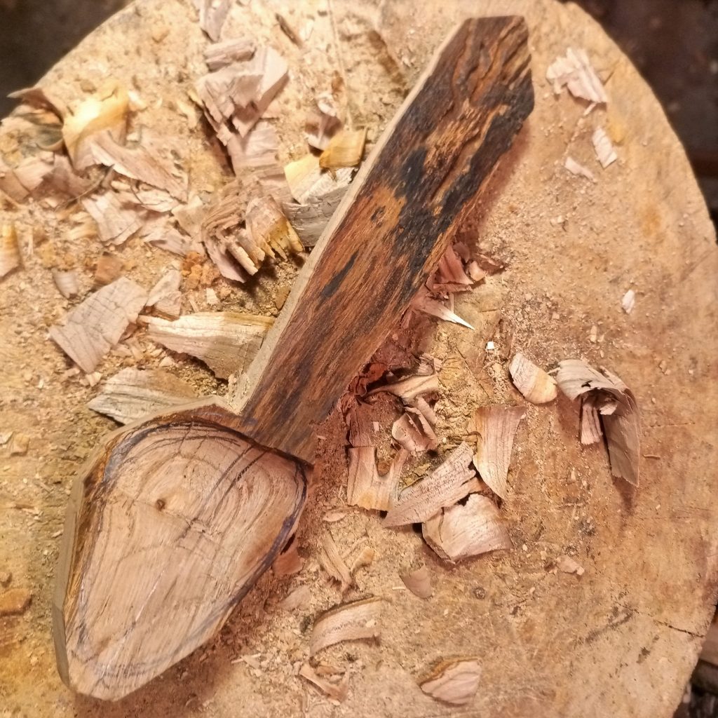 A spoon takes shape after being rough cut from the log